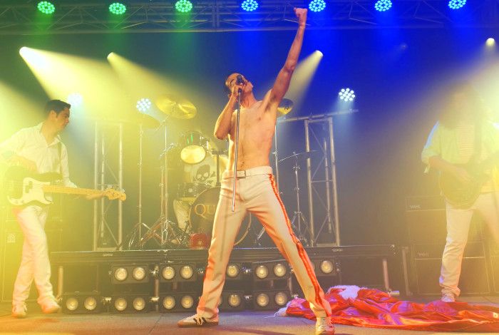Queen tribute act, performing onstage amongst coloured lights