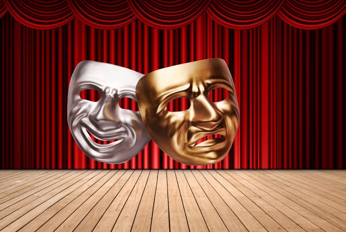 Drama masks - one smiling, one frowning, in silver and gold against a stage background with a red curtain