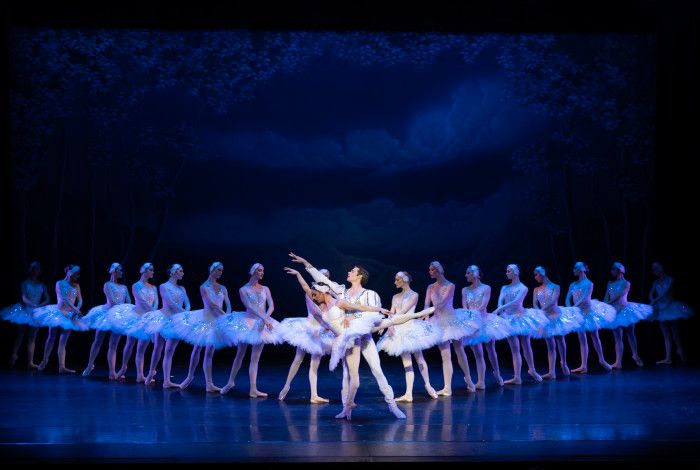 Ballett dancers on the stage with a dark blank background.