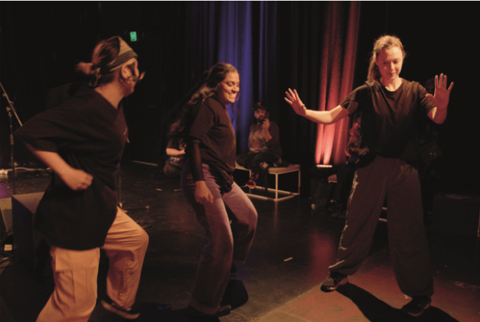 People dancing in a darkened studio.