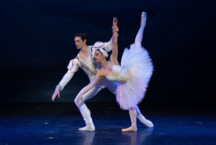 Two people doing ballet moves on stage