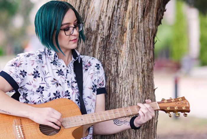 A lady playing a guitar
