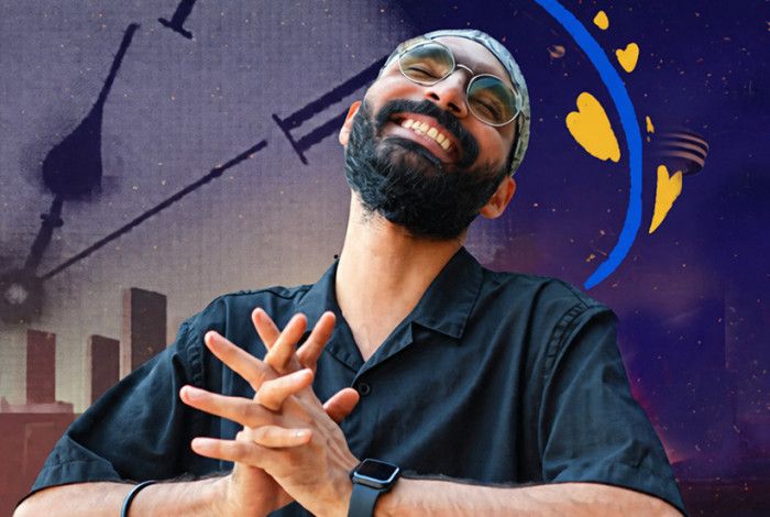 A person smiling and holding his hands together