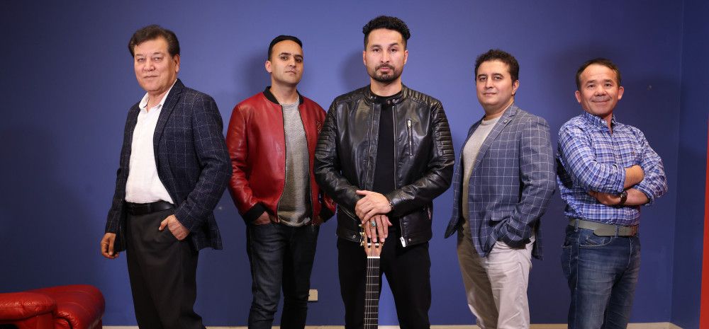 Group of male musicians in a line with a guitar