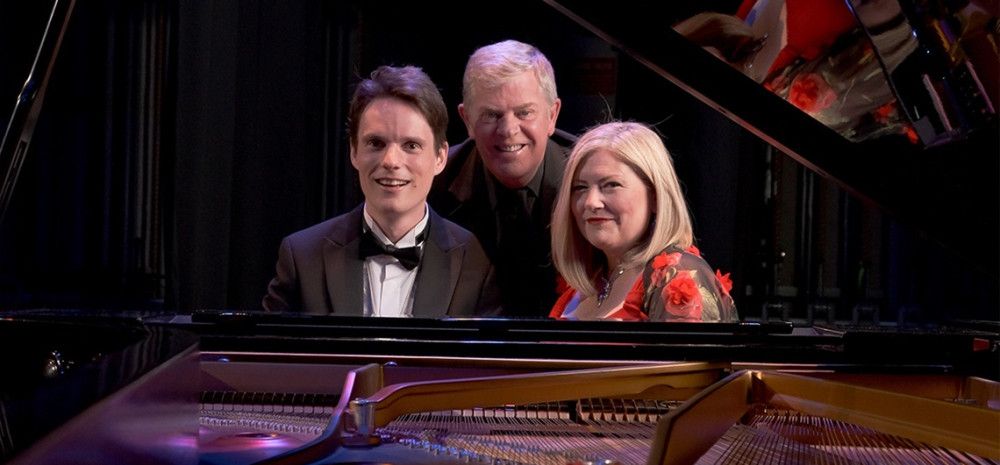 Three performers sitting behind a piano.