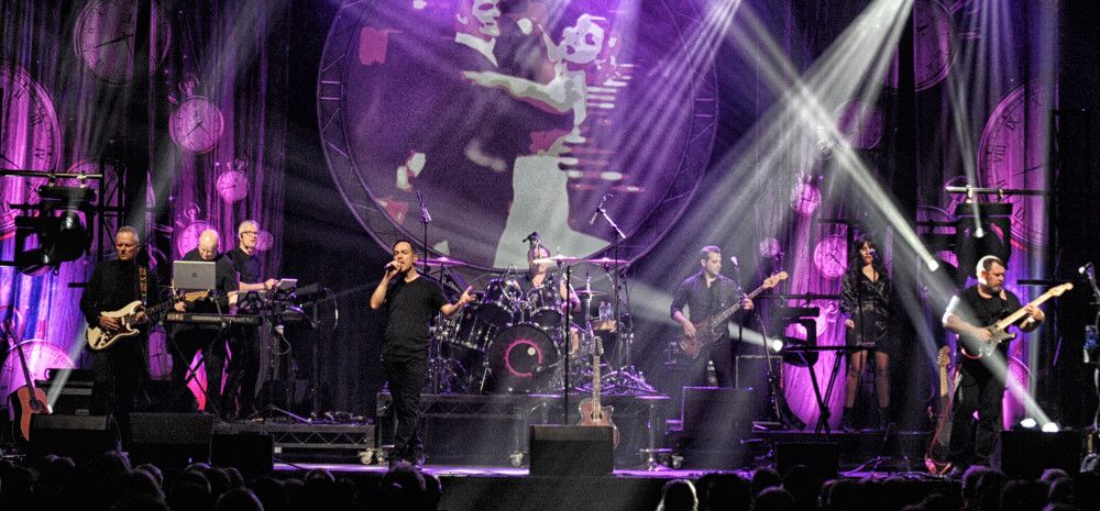 Band onstage lit by purple and white lighting