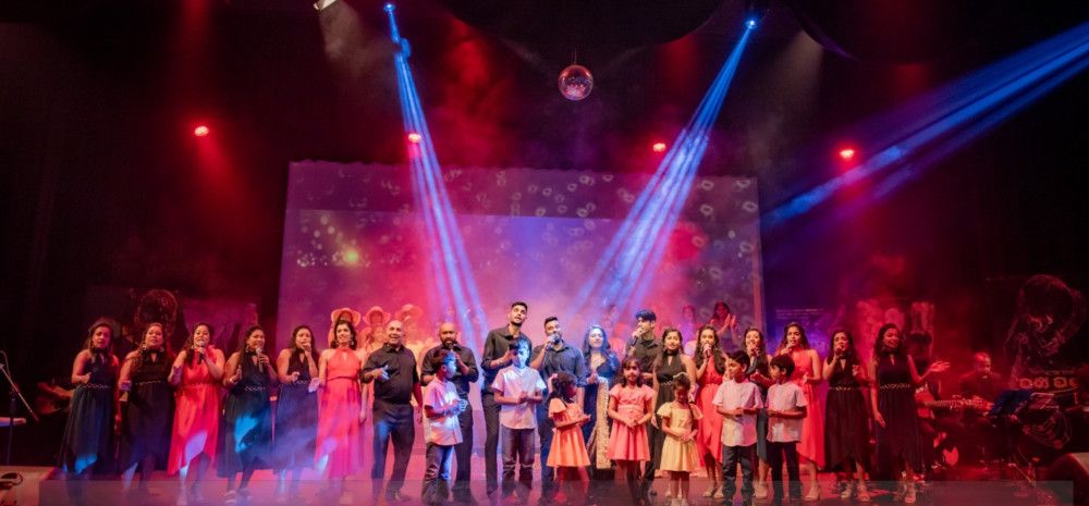 crowd on stage in front of fog with lights