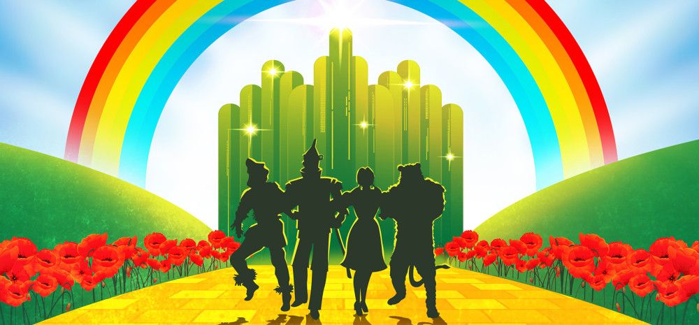 Four people walking on a yellow brick road towards a rainbow