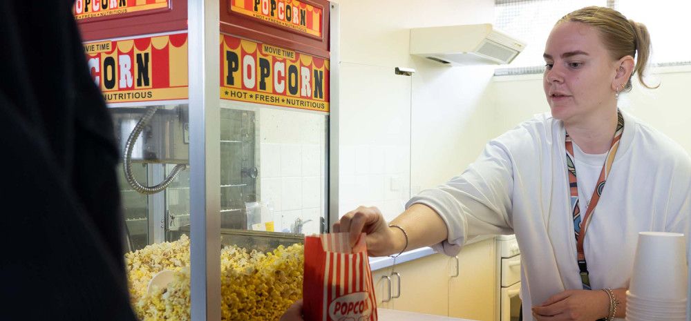 A staff member serving popcorn