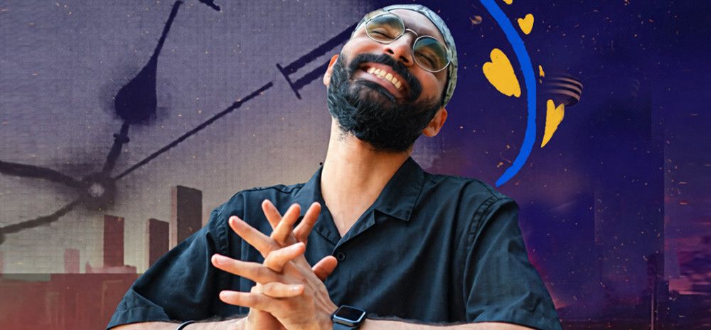 A person smiling and holding his hands together