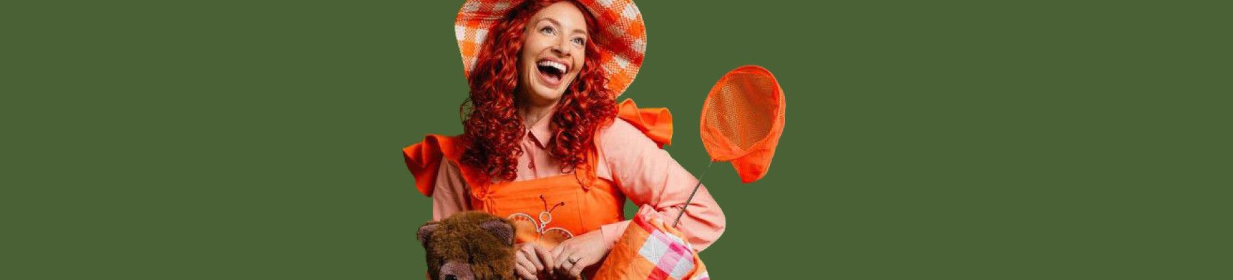 A lady with a picnic basket with a teddy bear and blanket