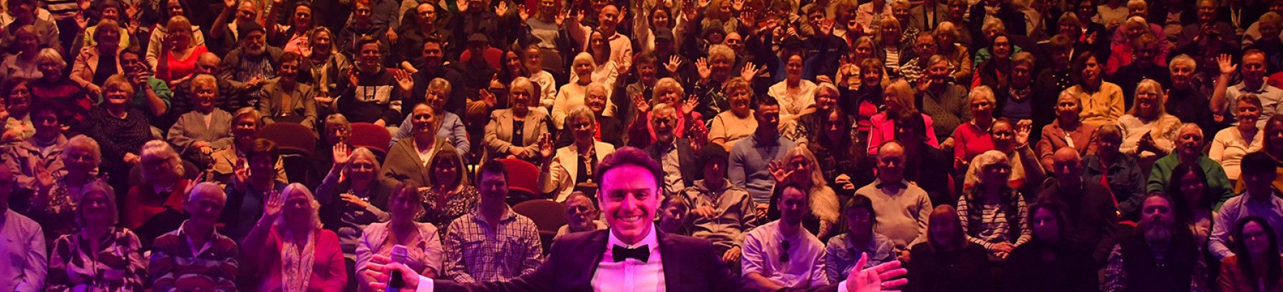 A man in front of audiences at a performance